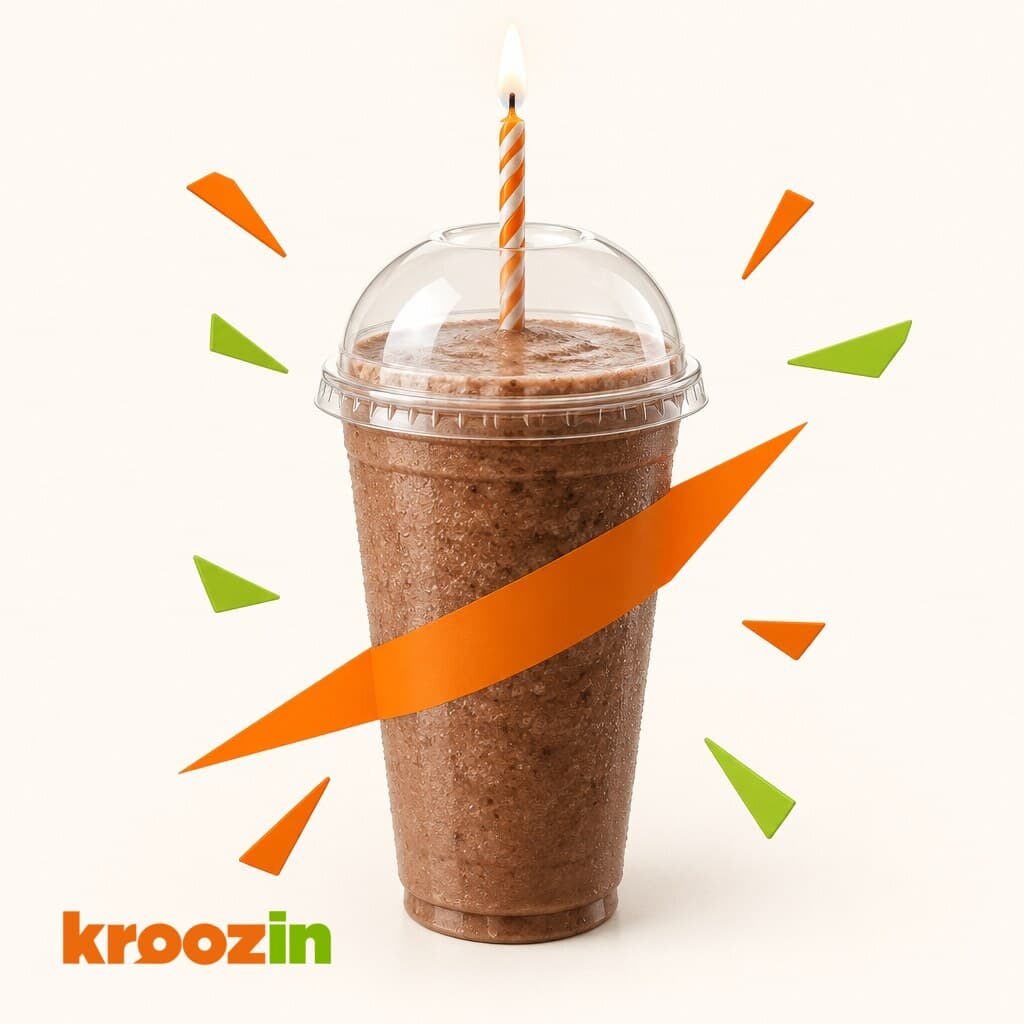 A Kroozin cup with a single lit candle.