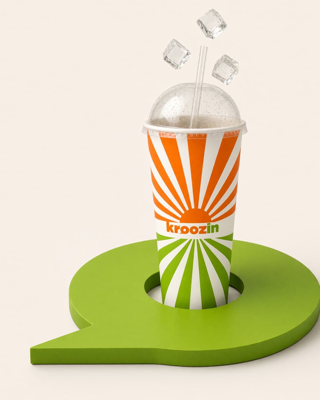 The tall Kroozin 44oz sunburst cup standing in a green pin-shaped coaster, ice cubes in the air above the lid.